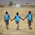 Niños refugiados, junto a un viejo autocar en Dundu (Angola).