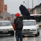 El viento da la vuelta al paraguas de un joven en León en una imagen de archivo.