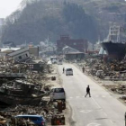 Varias personas caminan por las calles de la devastada Kesennuma.