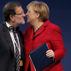 Rajoy y Merkel se saludan durante un congreso del Partido Popular Europeo.