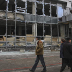 Los peatones observan un edificio que resultó dañado tras un bombardeo en Donetsk (Ucrania).