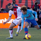 El defensa del Rayo Vallecano Jordi Amat lucha por el balón ante el delantero francés del Atlético, Antoine Griezmann. RODRIGO JIMÉNEZ