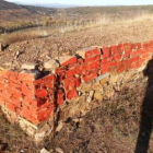 El autor de la pintada usó un aerosol rojo para marcar, piedra a piedra, un tramo de la muralla.