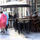 Turistas protegidos contra la lluvia en la calle Ancha, donde las terrazas estaban ayer recogidas por el mal tiempo
