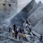 Palestinos inspeccionan los restos de Al-Basha, un edificio que fue destruido por un ataque aéreo israelí en Gaza