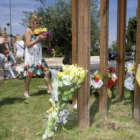 Familiares de las víctimas del incendio depositan flores en el monumento.
