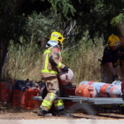 Bomberos trasladan bombonas de butano de la casa donde se produjo la explosión. JAUME SELLART