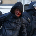 La policía detiene a un manifestante 'Blockupy' herido en la cara.