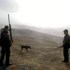 Dos cazadores, bajo la niebla, en una jornada cinegética.