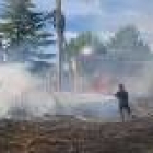 Un bombero intenta sofocar las llamas que ya se encuentran en el mismo límite de una edificación