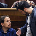 Pablo Iglesias y Alberto Garzón conversan en el hemiciclo del Congreso.