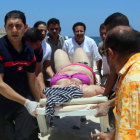 Una mujer herida es evacuada en una camilla, ayer, en la playa de Susa.