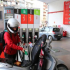 Una joven reposta carburante para su moto en una gasolinera, el martes.