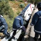 Los bomberos trabajan en la zona del siniestro, frente al autobús