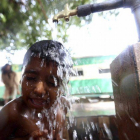 Un niño se refresca en un caluroso día en Karachi, Pakistán.