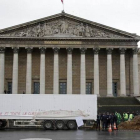 Agentes franceses permanecen junto al camión que ha vertido su carga de estiércol, esta mañana en París.