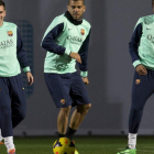 Alves, en medio de Messi y Neymar, durante un entrenamiento del Barcelona.