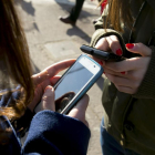 Jóvenes utilizando el móvil a la salida de su instituto.