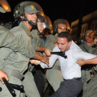 Los antidisturbios marroquís detienen a un hombre que participaba en la manifestación de Rabat contra el indulto al pederasta español, este viernes.