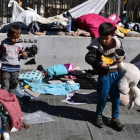 Unos niños buscan sus juguetes en la plaza Victoria de Atenas antes de ser trasladados a las instalaciones olímpicas.