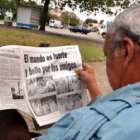 Un hombre observa un periódico con las fotos del líder cubano Fidel Castro junto al presidente de Br