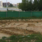 Al fondo, vial de La Lastra que atravesaría el yacimiento de Puente Castro (en primer término).