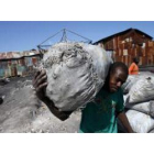 Un hombre traslada un saco de carbón del Puerto de La Saline para su venta en los mercados de Puerto