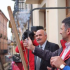El alcalde, mechero en mano, observa cómo arde la mecha del cohete.