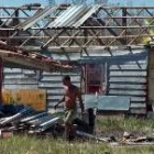 Un hombre pasa frente a una casa que perdió el techo durante el paso del huracán Charley