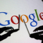 La silueta de dos hombres con el logo de Google de fondo.