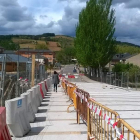 Una vecina cruza el puente sobre el río Cúa.