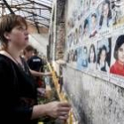 Una joven coloca una vela en las paredes de la escuela de Beslán en recuerdo de las víctimas