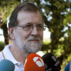 El presidente del Gobierno Mariano Rajoy atiende a los medios de comunicacion durante su paseo por las orillas del rio Umia a su paso por la localidad de Ponte Arnelas en Ribadumia Pontevedra en el inicio de sus vacaciones.