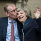 Theresa May recibe un beso de su marido, Philip John May, en el Palacio de Westminster