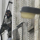 Un agente utiliza una cámera extendida para espiar en el interior de un piso, en Molenbeek, este lunes.