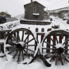 Un vehículo circula rodeado de nieve por las inmediaciones de Puebla de Lillo.