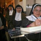 Un grupo de carmelitas firma en el libro de visitas de la exposición