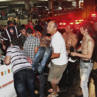 Un grupo de personas trasladan a una víctima del incendio de la discoteca Kiss, en Santa Maria (Brasil) este domingo.