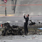 Un artificiero examina los restos del coche bomba que ha explotado este jueves en el centro de Atenas.