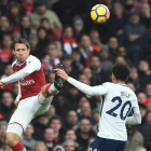 Laurent Koscielny despeja un balón ante la presencia de Dele Alli.