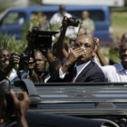 Aristide saluda a sus seguidores al llegar a Haití.