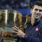 Novak Djokovic posa con el trofeo del Abierto de Pekín tras imponerse a Tomas Berdych.