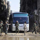 Militares del Ejército sirio supervisan un autobús que transporta combatientes vinculados a Al Qaeda durante una evacuación desde el campo de refugiados palestinos de Yarmuk, cerca de Damasc
