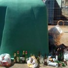 Botellas fuera de los contenedores de reciclaje de vidrio. DL
