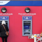 Dos mujeres retiran efectivo de cajeros automáticos de Tesco Bank en Liverpool.