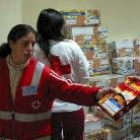 Una voluntaria de Cruz Roja distribuye arroz entre las familias más necesitadas