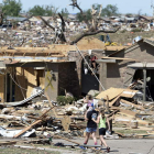 Una pareja y su hija caminan entre los escombros, en Moore, Oklahoma.