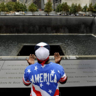 Un hombre reza en la piscina de la torre norte durante un acto en memoria de las víctimas de los ataques del 11S.