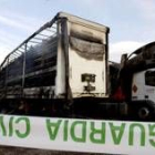 Un precinto de la Guardia Civil rodea uno de los camiones calcinados