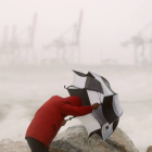 Un hombre con un paraguas se protege del fuerte viento en la playa Seacaba de Málaga. JORGE ZAPATA